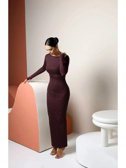 Elegant black maxi dress with heart print, long sleeves, and boat neckline, showcasing sophisticated style.