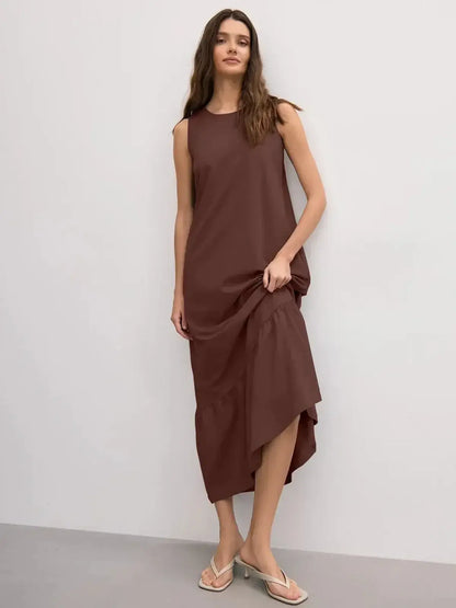 Model wearing a chocolate-hued sleeveless maxi dress with a ruffle hem, showcasing chic simplicity and elegance.