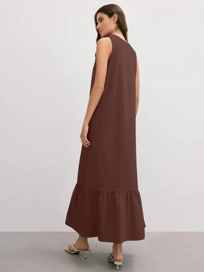 Back view of a model wearing the chocolate-hued Maxi Dress Reverie with a ruffle hem.