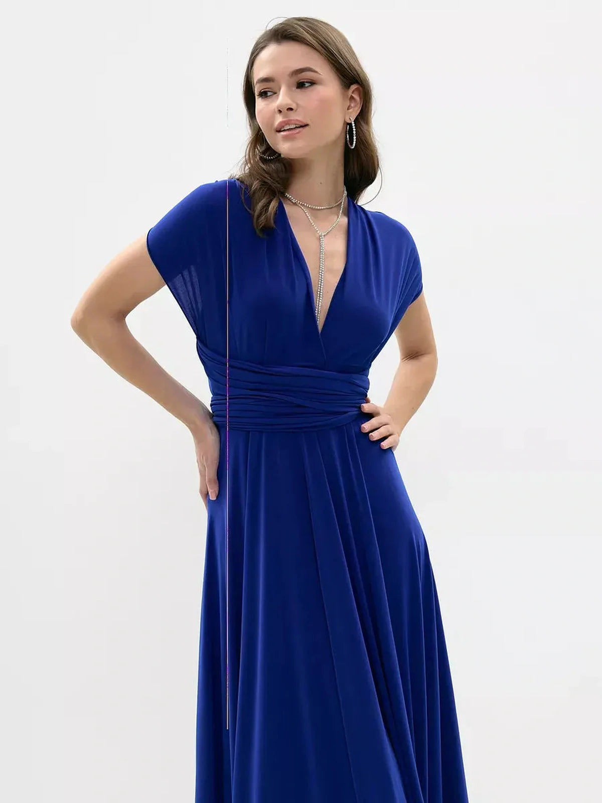 Model wearing a vibrant blue maxi dress with a twisted design and flowing silhouette, perfect for formal occasions.