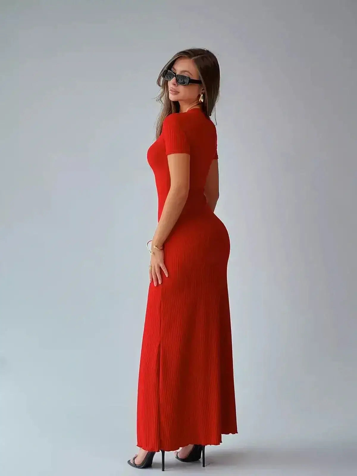 Elegant red ribbed maxi dress sculpted to fit, perfect for summer events and wedding guest attire.