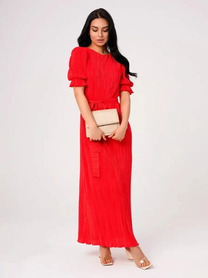 Red Maxi Dress Solaria with pleats and puff sleeves, styled with a clutch for elegant summer events.