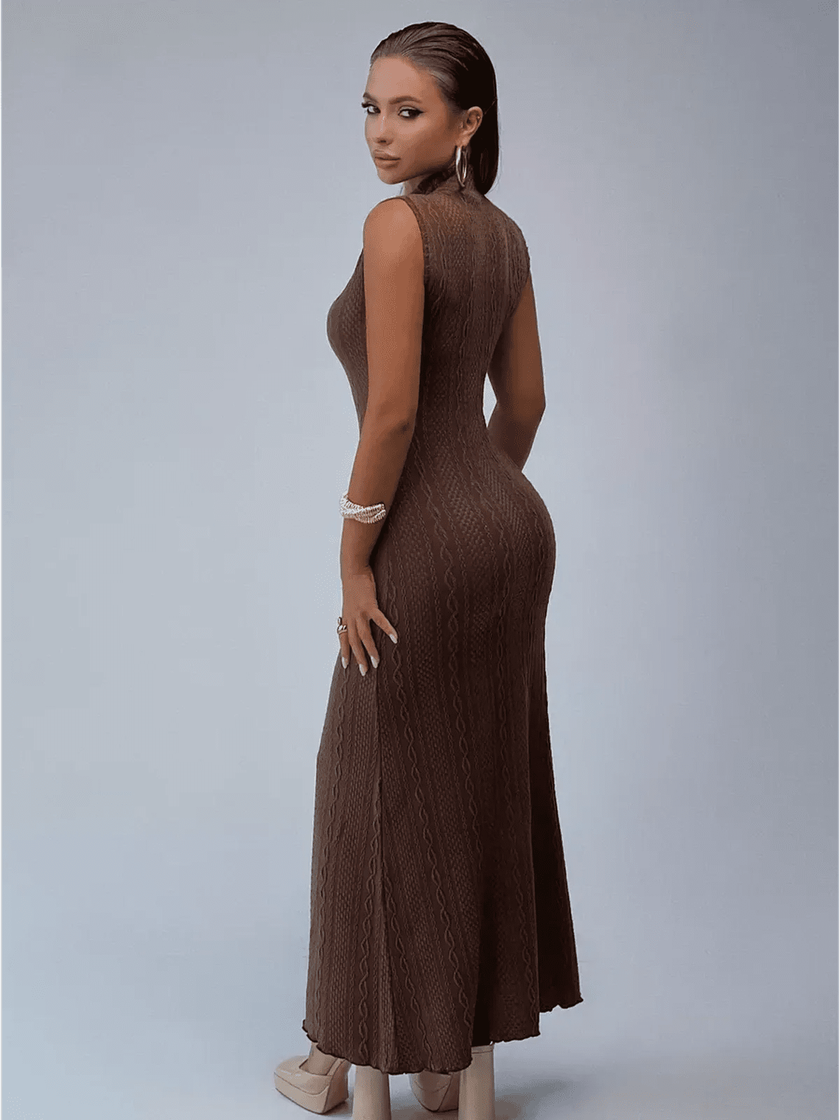 Elegant woman in a brown cable knit maxi dress showcasing a sculpted silhouette and mock neckline.