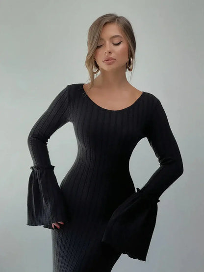 Model wearing the black Meridian Maxi Dress with flared cuffs, showcasing sculptural elegance and a sophisticated silhouette.