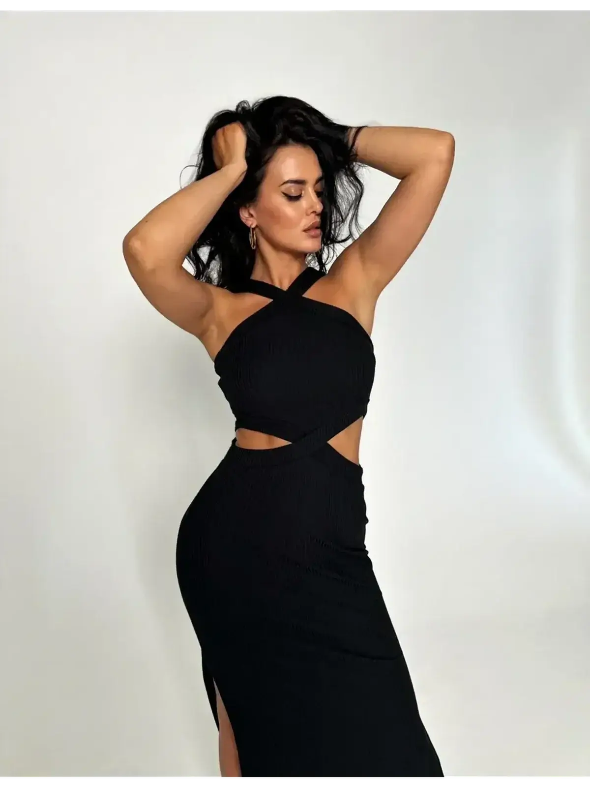Sculpted black midi dress with cutout waist, cross-strap neckline, and side slit, perfect for elegant occasions.
