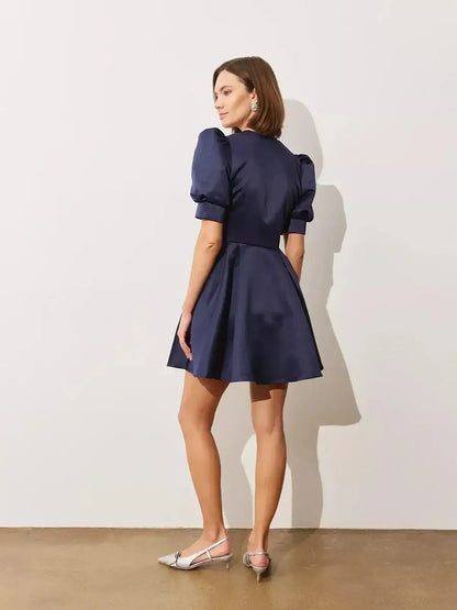 Elegant Midnight Bloom mini dress featuring dramatic puff sleeves and a structured flared skirt in satin finish.