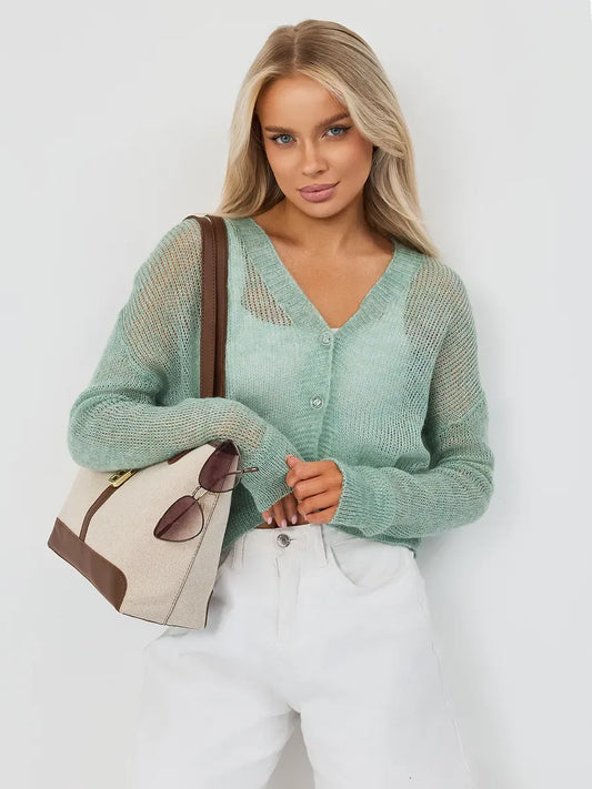 Model showcasing the Mint Cardigan by Lauven in oversized mohair-blend knitwear, soft green with a stylish bag.