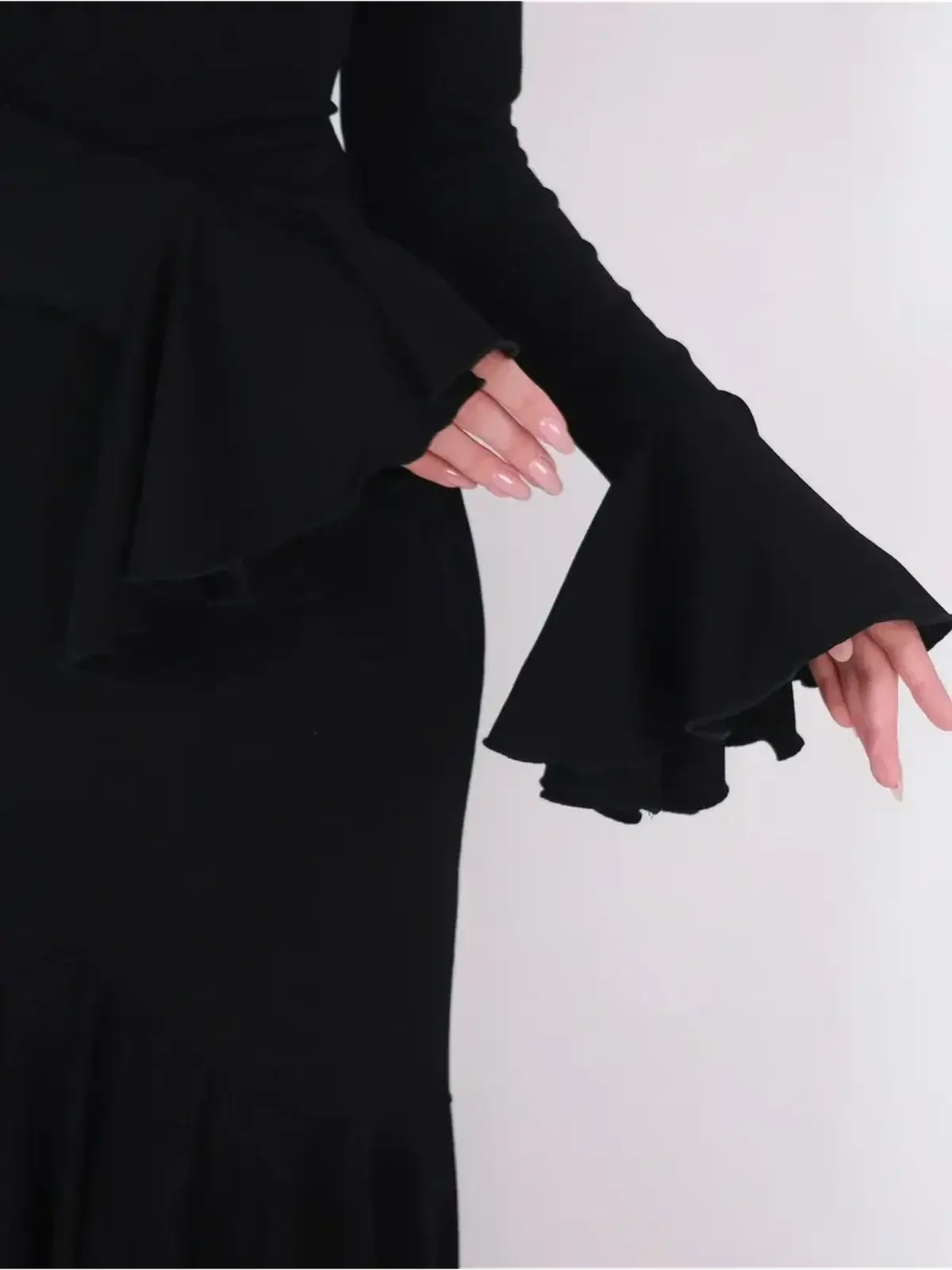 Close-up of Mirage Maxi Dress featuring elegant flared cuffs and a fitted silhouette in black fabric.