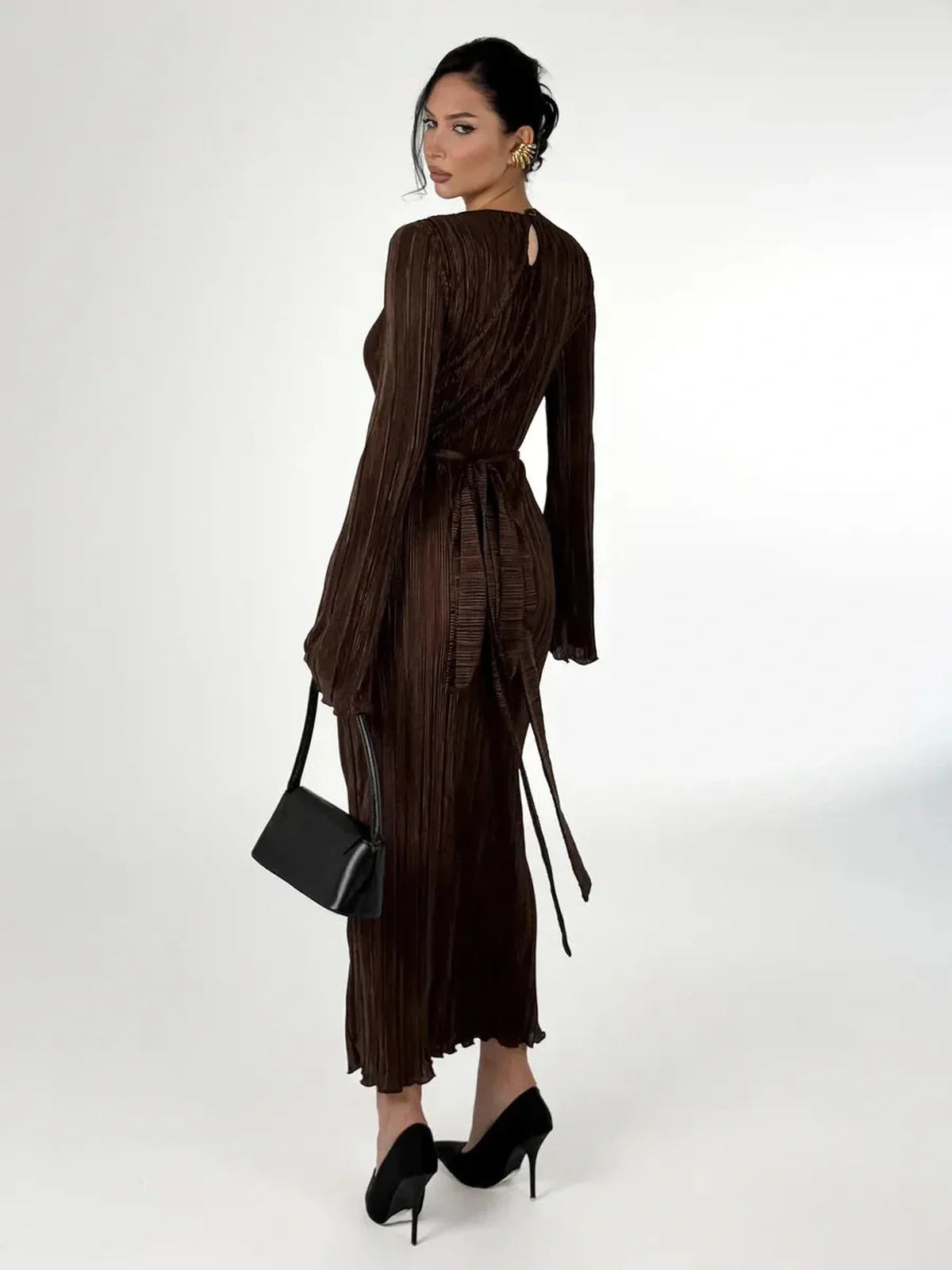 Woman in a mocha drape maxi dress with sculpted pleats and a matching belt, showcasing elegant fluidity and style.