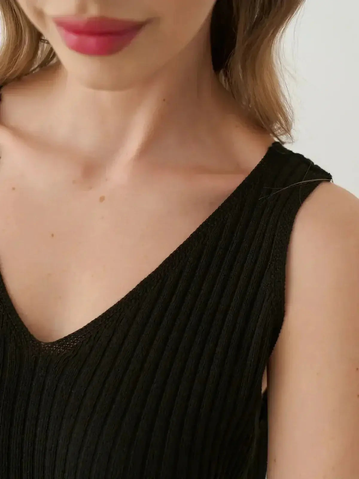 Close-up of the Muse Knit Maxi Dress featuring a modern V-neckline and ribbed knit texture.