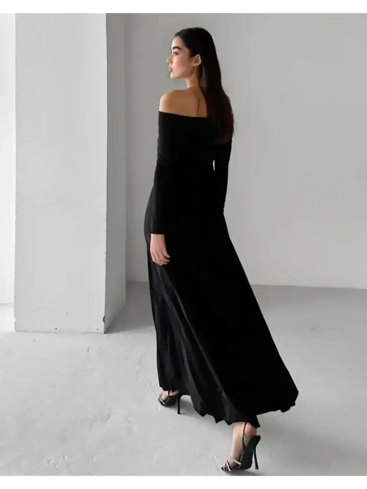 Elegant Muse Maxi Dress in black, showcasing off-shoulder design and flowing silhouette on a model.