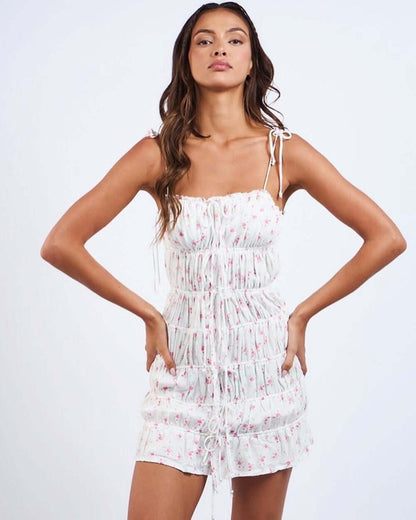 White floral mini dress with ruched detailing, perfect for summer occasions and special events.
