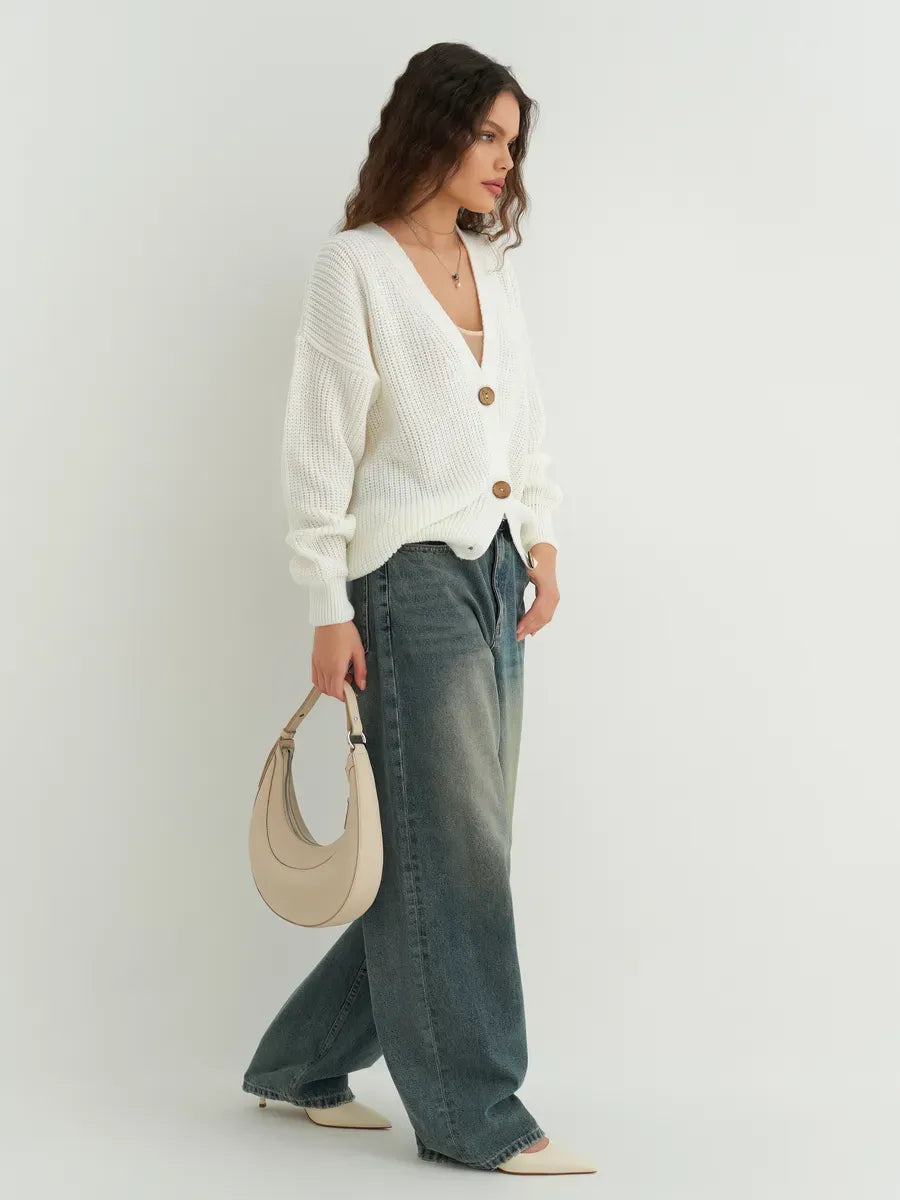 Noelle Cardigan by Lauven, elegant white knitwear with button detailing, styled with wide-leg jeans.