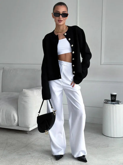 Noir Cardigan by Lauven styled with a black cropped knitwear piece and white wide-leg pants.