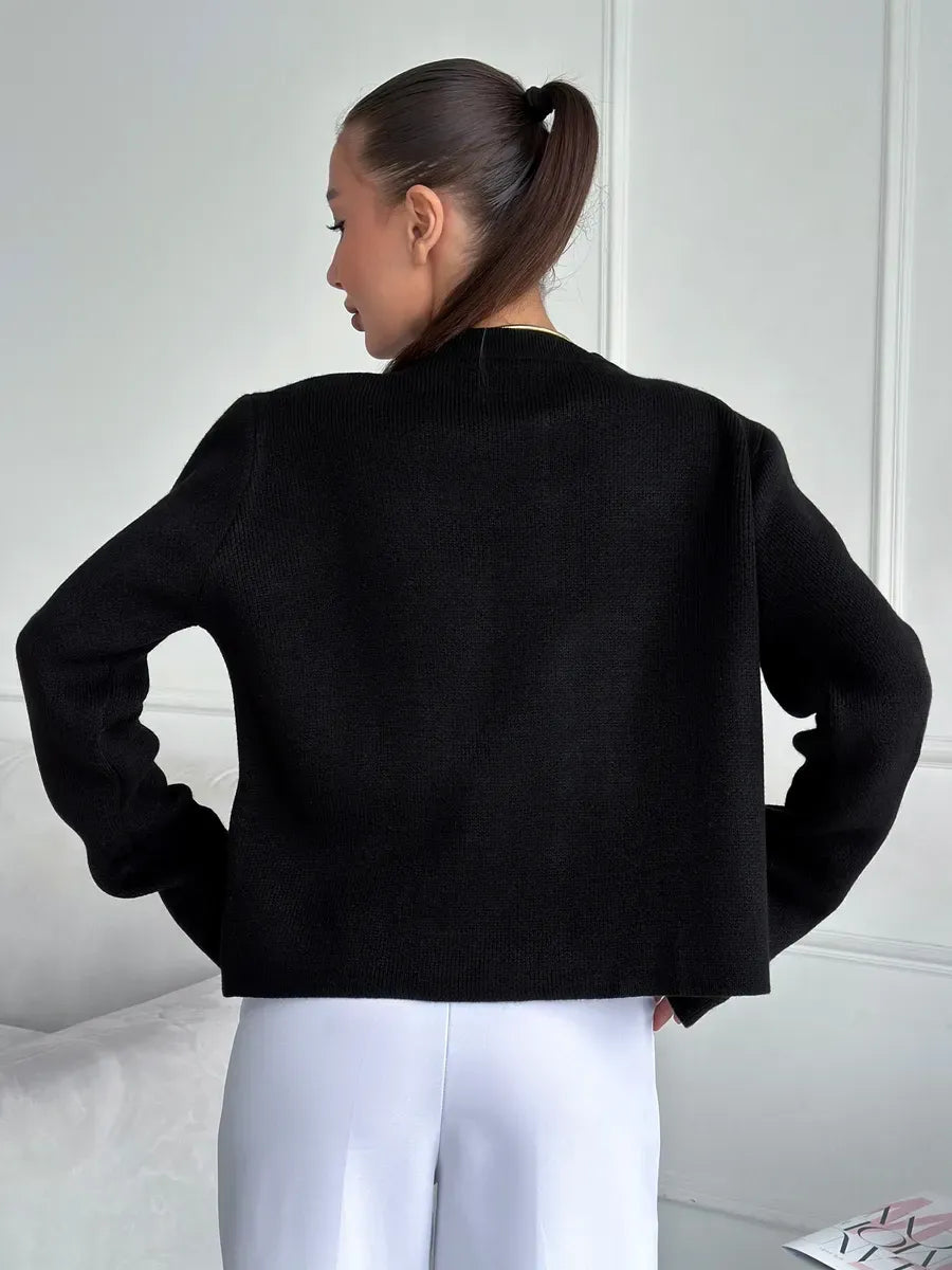 Model showcasing the back of the Noir Cardigan by Lauven, a cropped black knitwear piece for modern women.