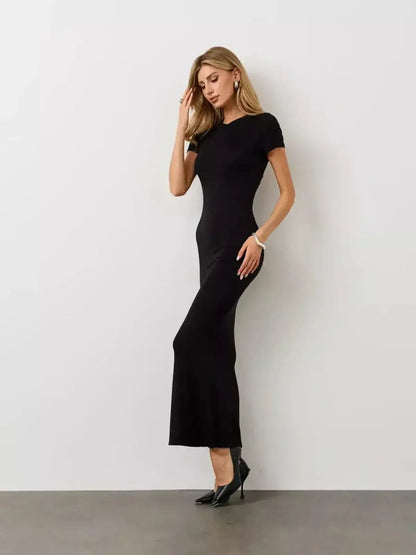 Model wearing the Noir Curve Maxi Dress by Lauven, showcasing a sculpted silhouette and a flared maxi hem in iconic black.