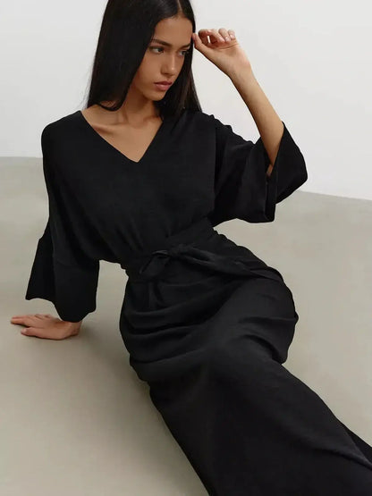 Model wearing the Noir Drift Maxi Dress, featuring kimono sleeves and a V-neckline, showcasing fluid elegance in black.