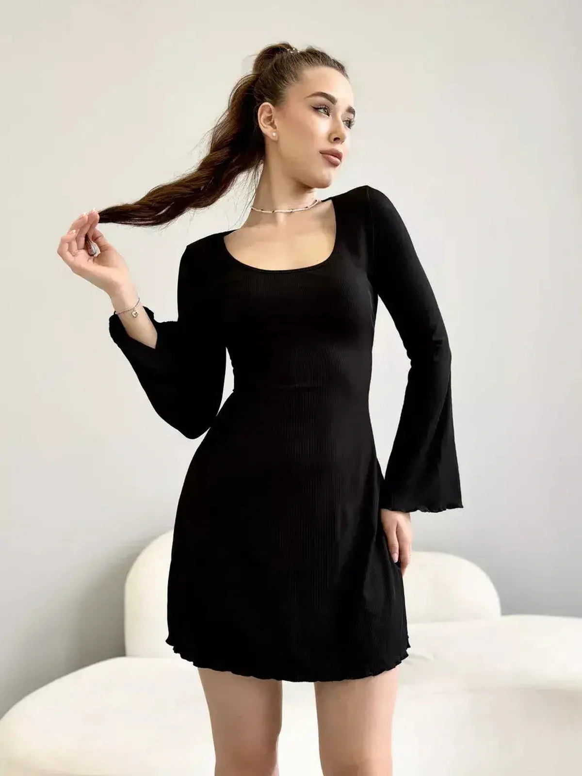 Noir Flare black mini dress with deep square neckline and flared long sleeves, perfect for formal or cocktail events.