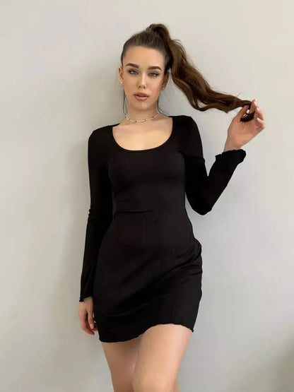Model wearing a figure-hugging black mini dress with a deep square neckline and flared sleeves, perfect for cocktail events.