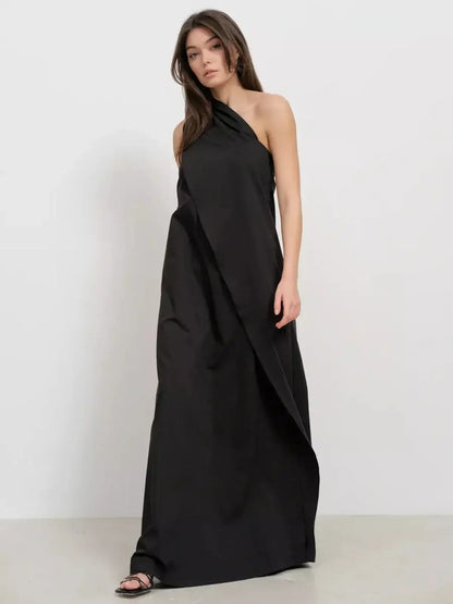 Noir Fold Maxi Dress featuring a one-shoulder silhouette and structured drape, perfect for elegant evening occasions.