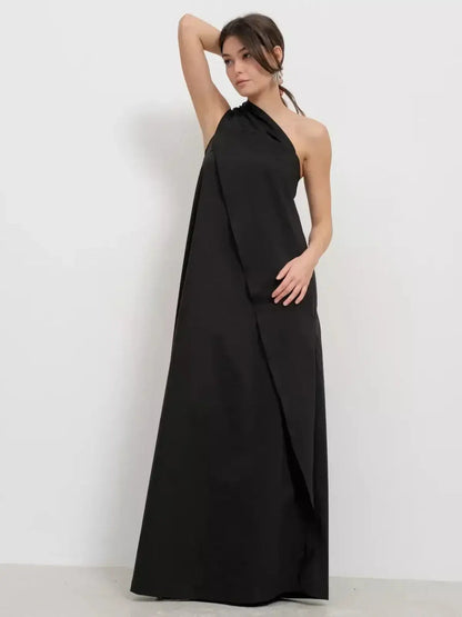 Elegant model wearing the Noir Fold Maxi Dress, showcasing a one-shoulder design and structured drape in classic black.
