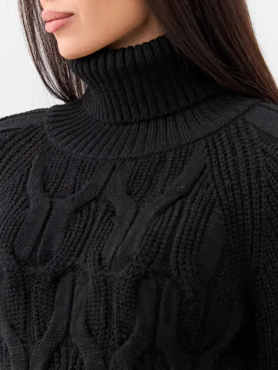Close-up of a woman wearing a black turtleneck sweater from Lauven, showcasing the Noir Knitwear chunky cable-knit design.