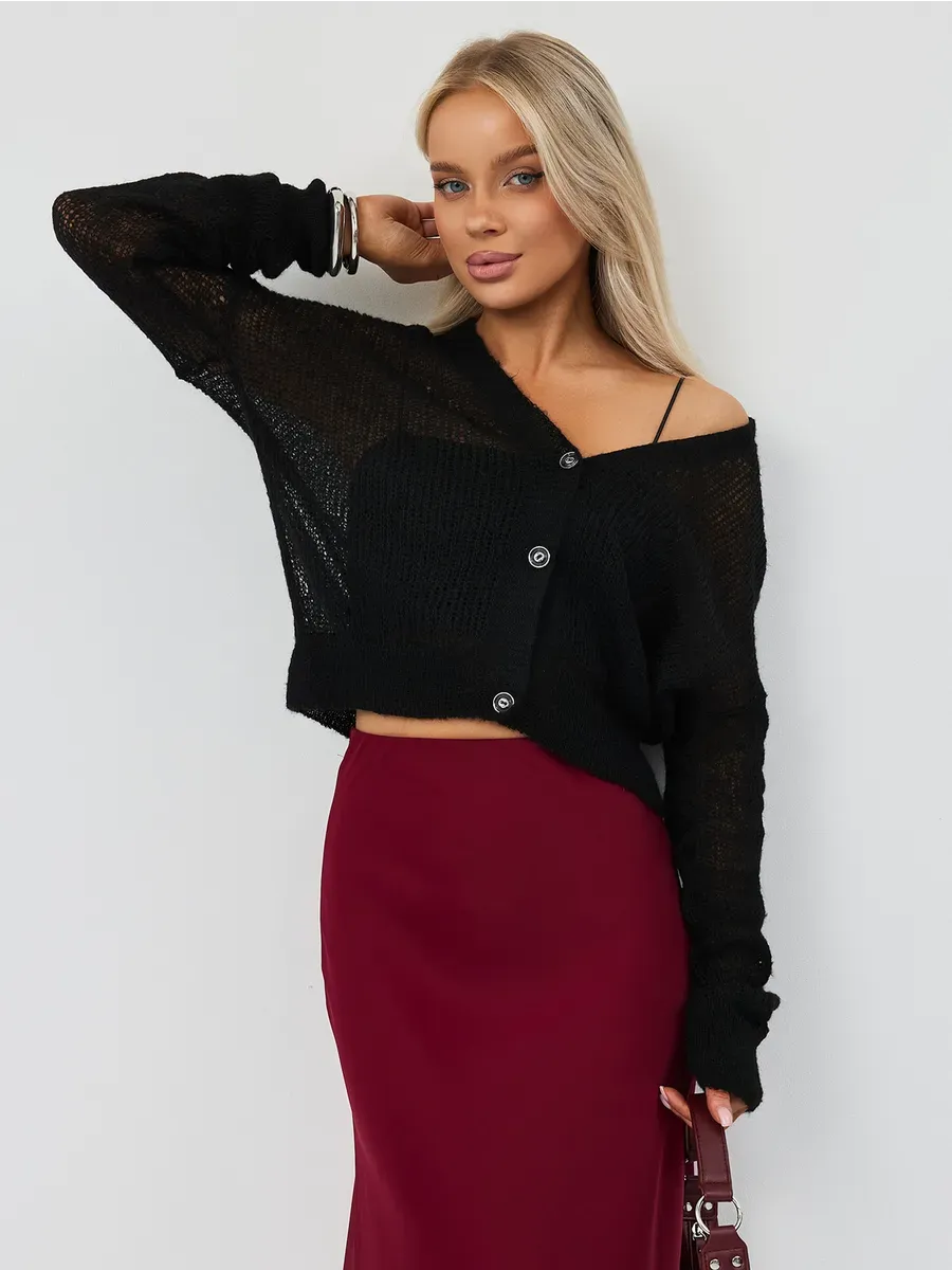 Model showcasing the Noir Luxe Cardigan by Lauven in chic black, styled with a burgundy skirt.