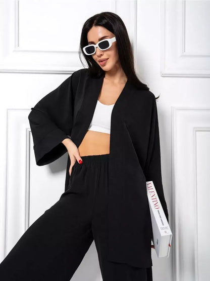 Noir Suit Set by Lauven featuring a chic oversized two-piece black outfit with wide-leg trousers and stylish sunglasses.