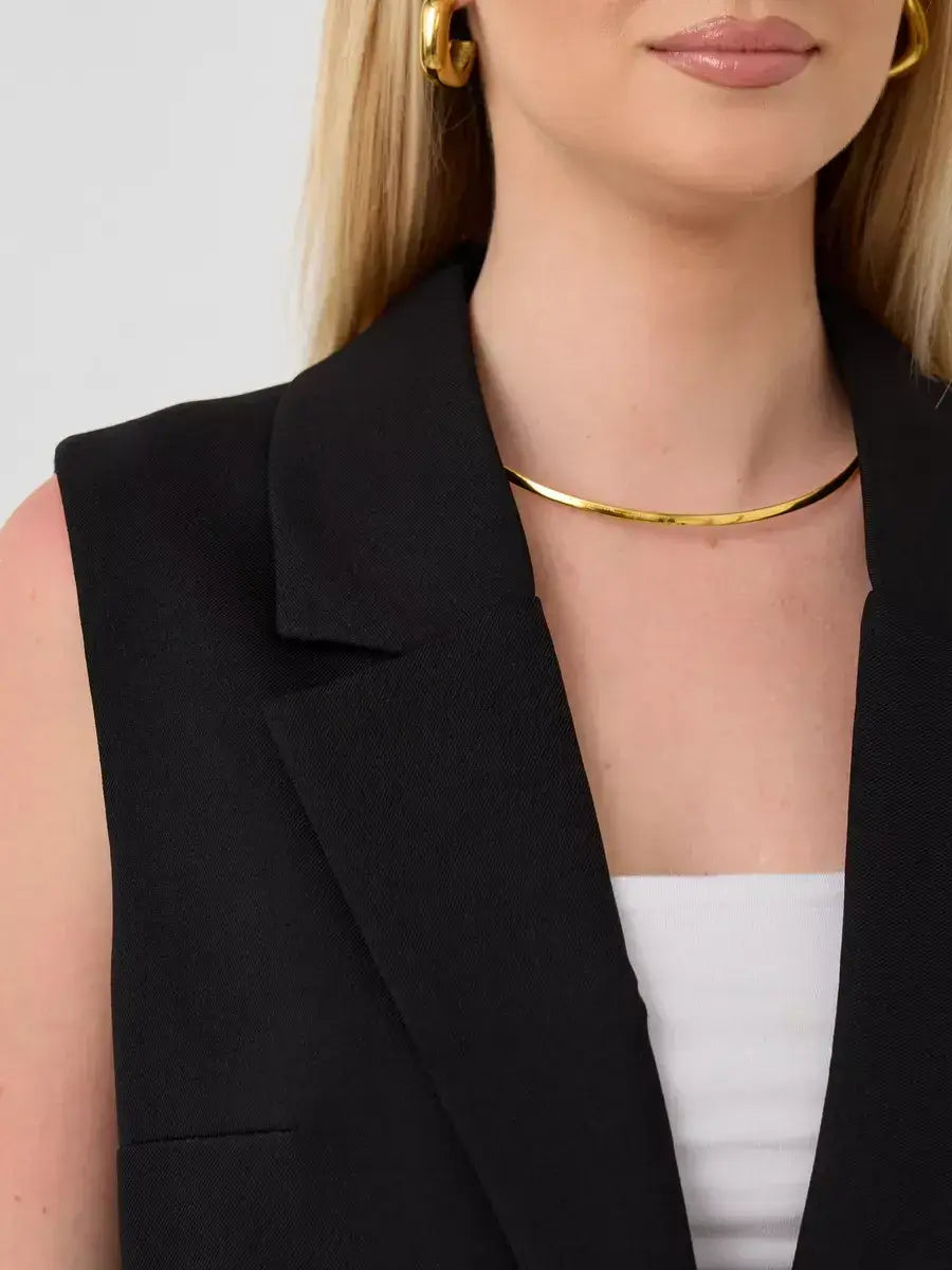 Close-up of a woman wearing the Noir Suit Set by Lauven, featuring a sleeveless black vest and elegant jewelry.