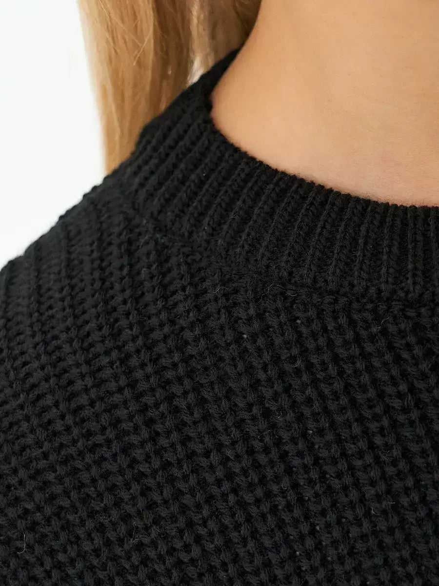 Close-up of the neck detail of the Noir Sweater by Lauven, showcasing its elegant oversized knit in classic black.