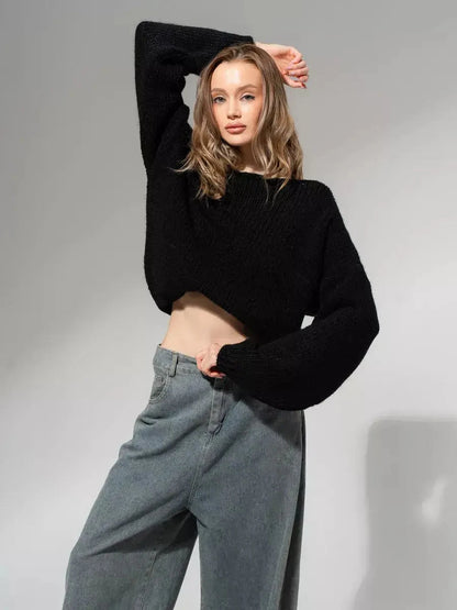 Model wearing Noir Sweater by Lauven, an oversized off-shoulder knit in classic black.