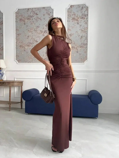 Model showcasing Noircocoa Maxi Dress in chocolate, featuring draped silhouette and sculptural ruching, perfect for elegant occasions.