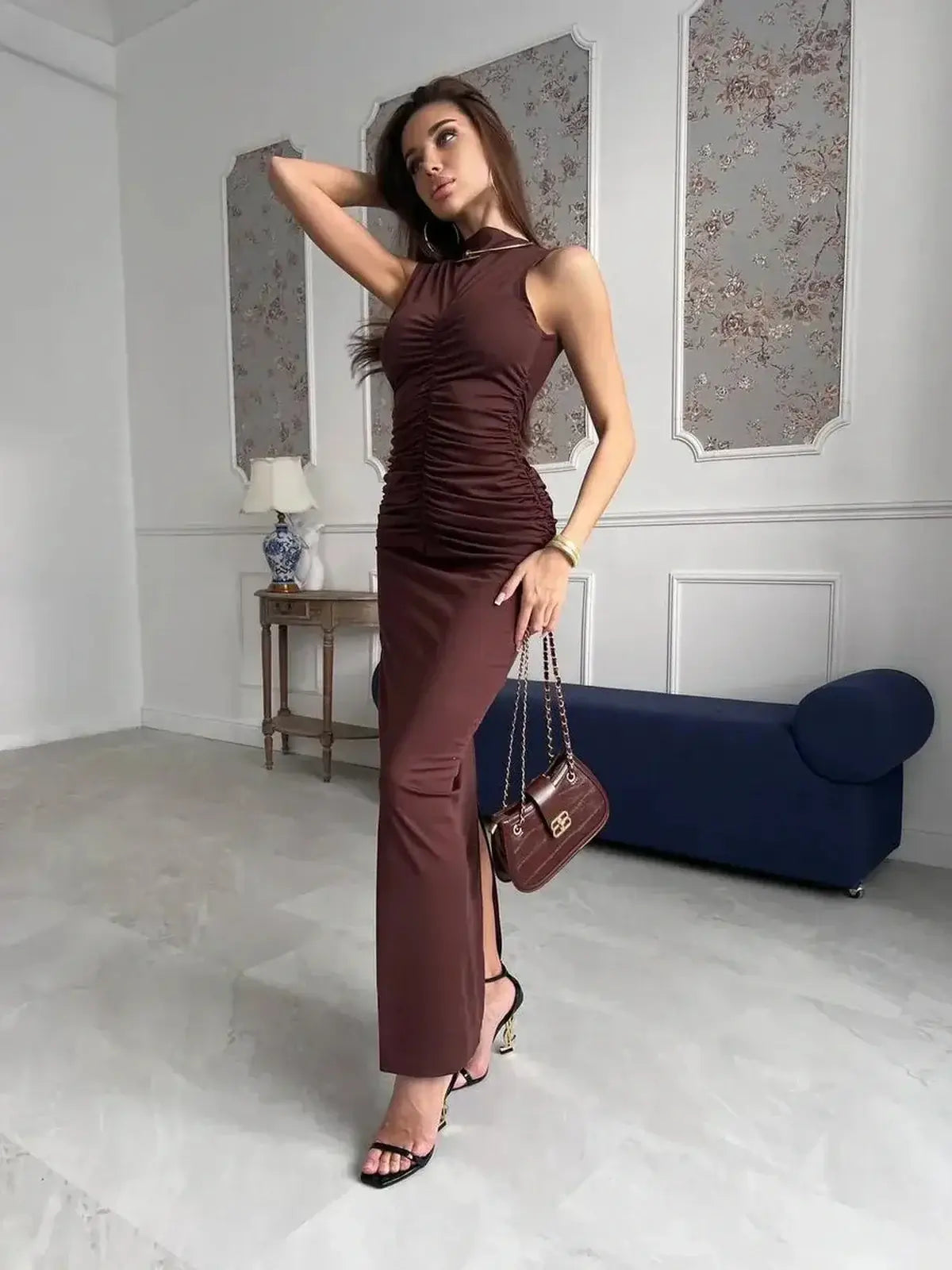 Model showcasing the Noircocoa Maxi Dress in chocolate tones, featuring draped silhouette and stylish accessories.
