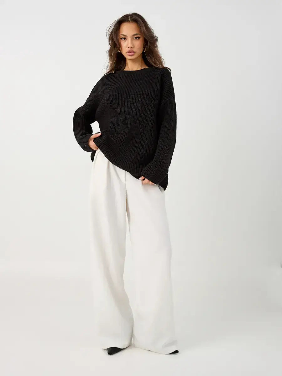 Nola Sweater by Lauven, oversized black knit with crew neck, styled with white wide-leg pants.