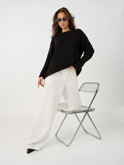 Nola Sweater by Lauven - Oversized black knit pullover styled with white trousers and sunglasses.