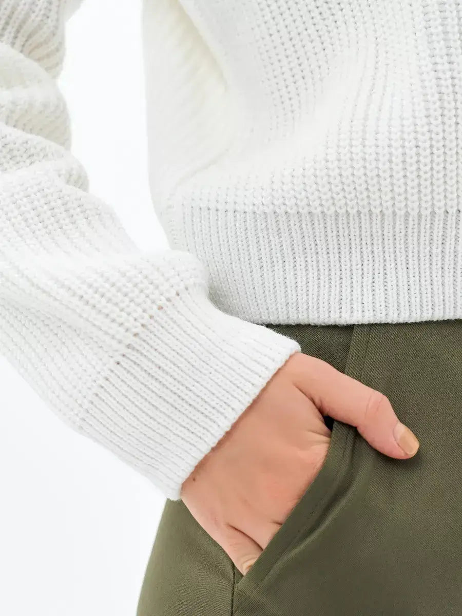 Close-up of the rib-knit sleeve of the Lauven Nova Sweater in white, highlighting its cozy elegance.
