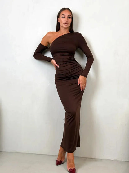 Model showcasing the Obsidian Curve Maxi Dress in chocolate brown, featuring a one-shoulder design and body-hugging silhouette.