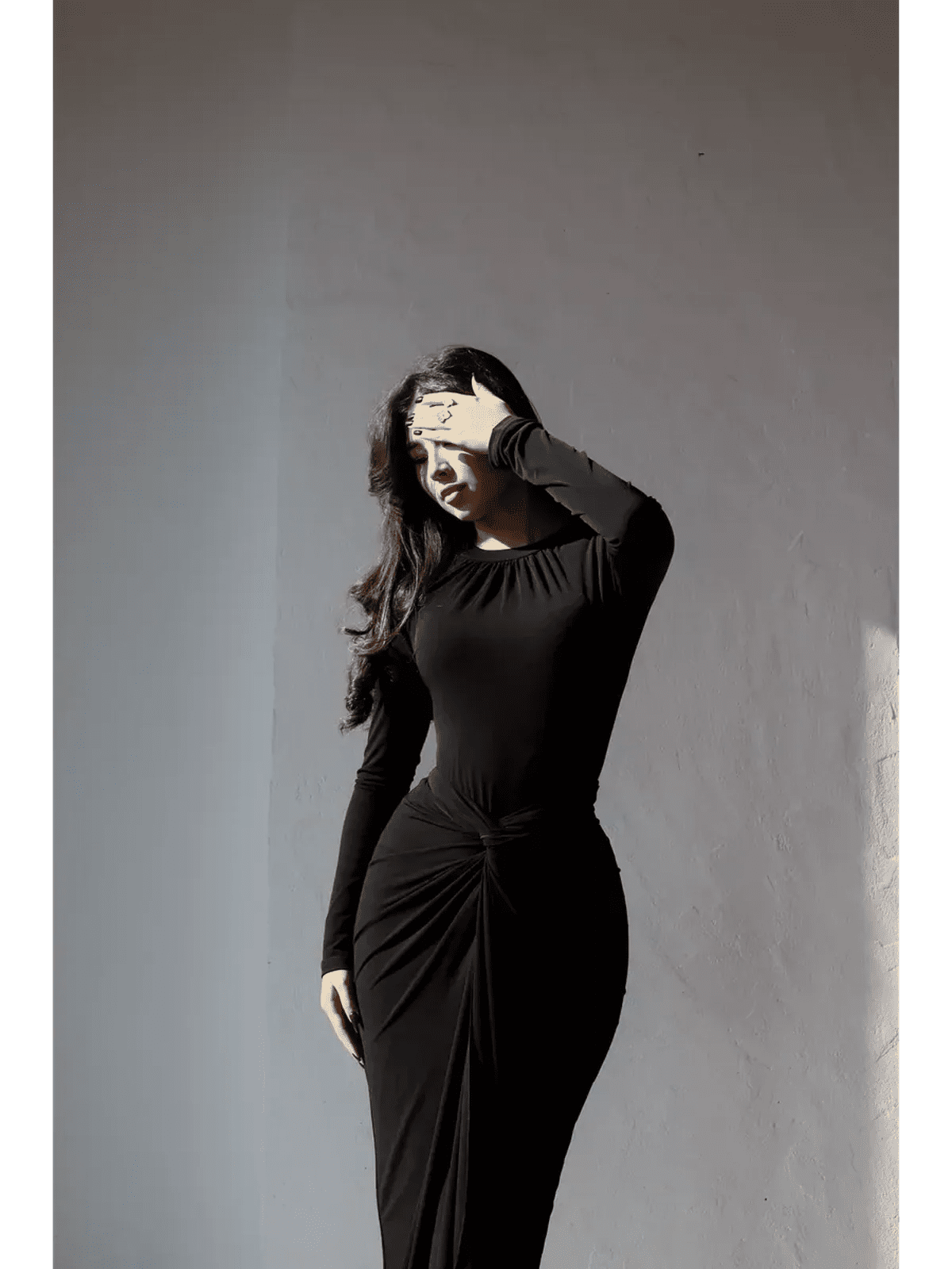Woman in an obsidian drape maxi dress with long sleeves, showcasing a sculpting fit and elegant silhouette.