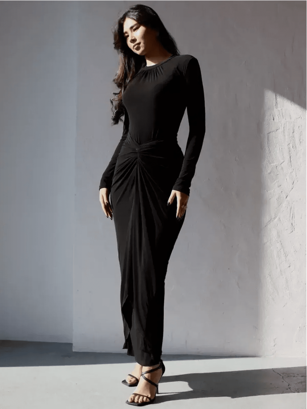 Model wearing the Obsidian Drape Maxi Dress, showcasing its sculpting fit and fluid drape in a chic black design.