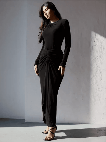 Model wearing the Obsidian Drape Maxi Dress, showcasing its sculpting fit and fluid drape in a chic black design.