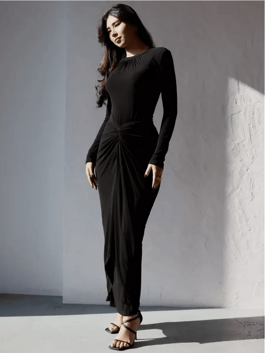 Model wearing the Obsidian Drape Maxi Dress, showcasing its sculpting fit and fluid drape in a chic black design.