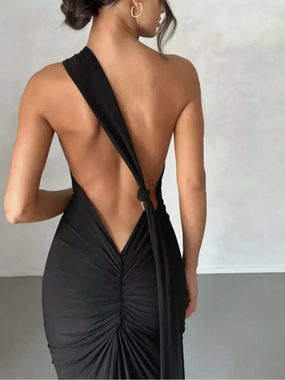 Back view of a woman in the Obsidian Maxi Dress showcasing its asymmetrical design and elegant drape.