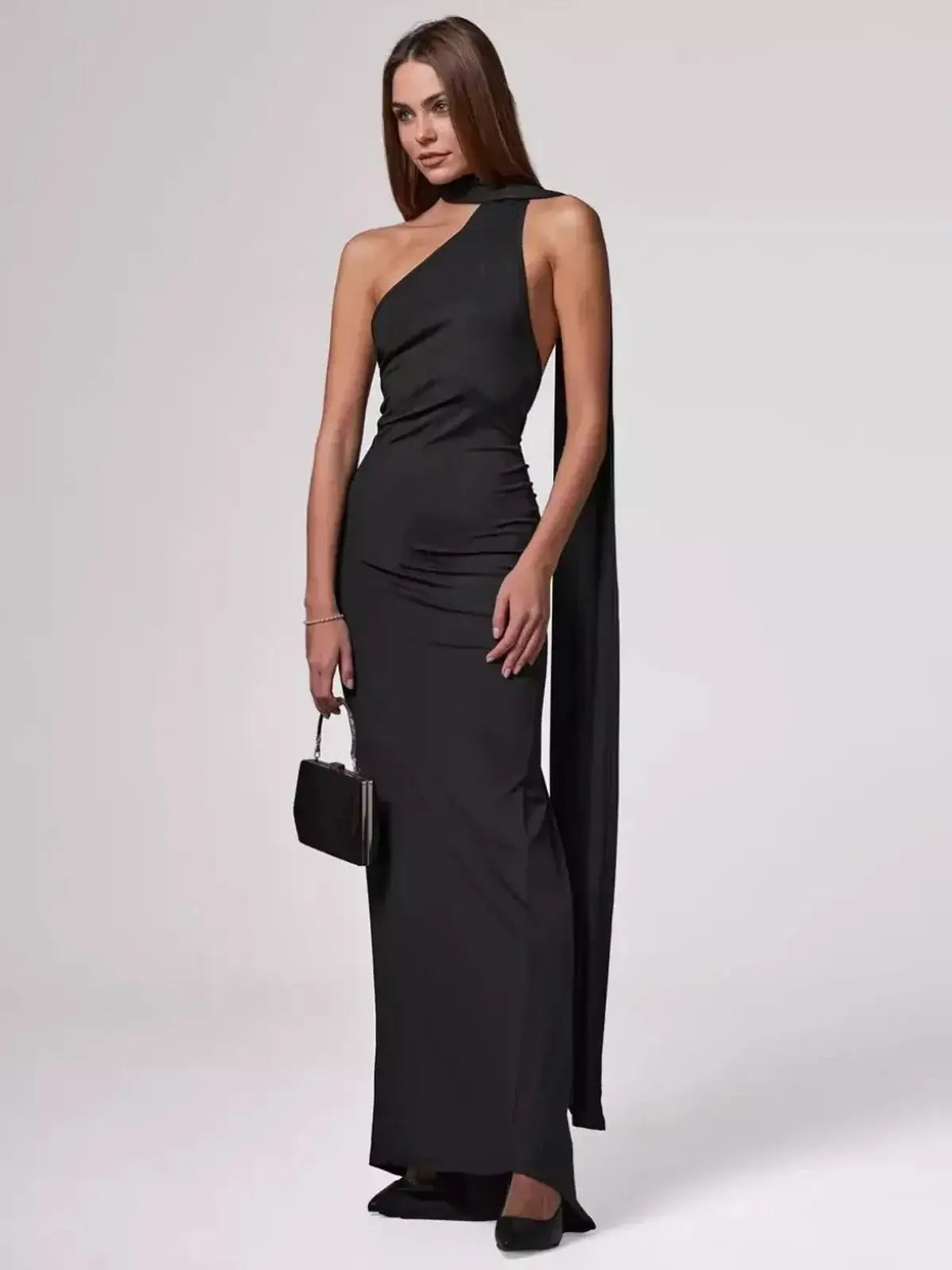 Elegant model wearing the Obsidian Maxi Dress, showcasing its one-shoulder design and flowing silhouette.