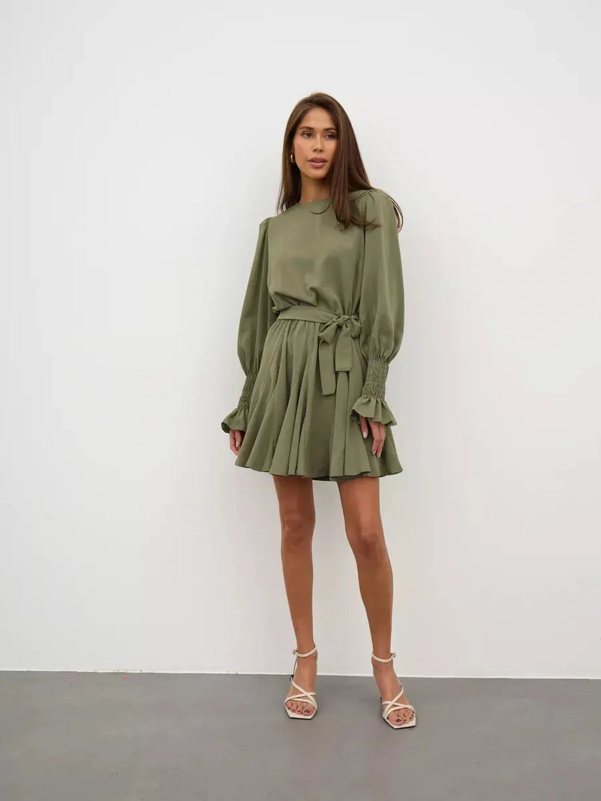 Olive Luxe Mini Dress featuring a refined silhouette, long sleeves, waist-cinching belt, and ruffle detailing in olive green.