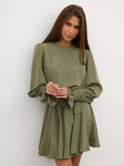 Olive Luxe Mini Dress featuring a refined silhouette, long sleeves, and ruffle detailing in a sophisticated olive green.