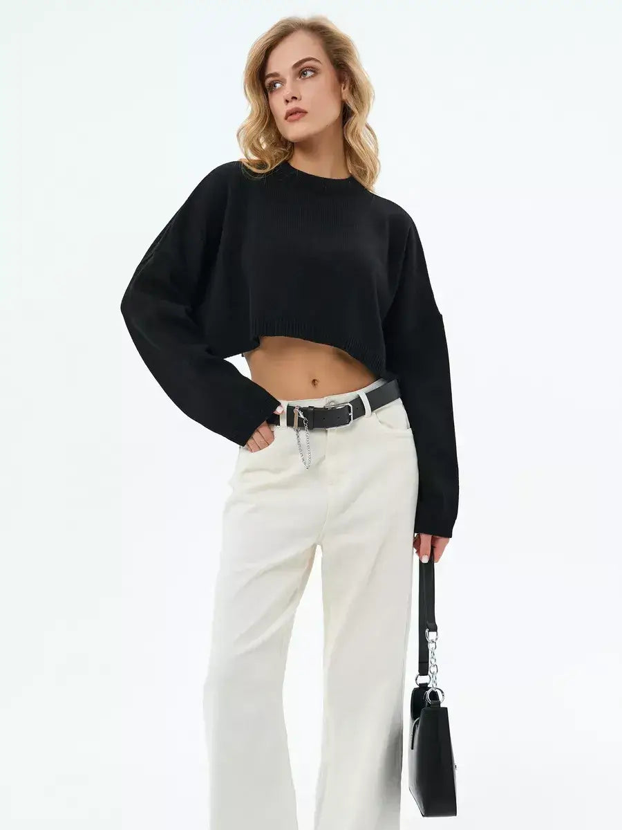 Model wearing the Onyx Sweater, a cropped oversized knit in black, styled with high-waisted trousers and accessories from Lauven.