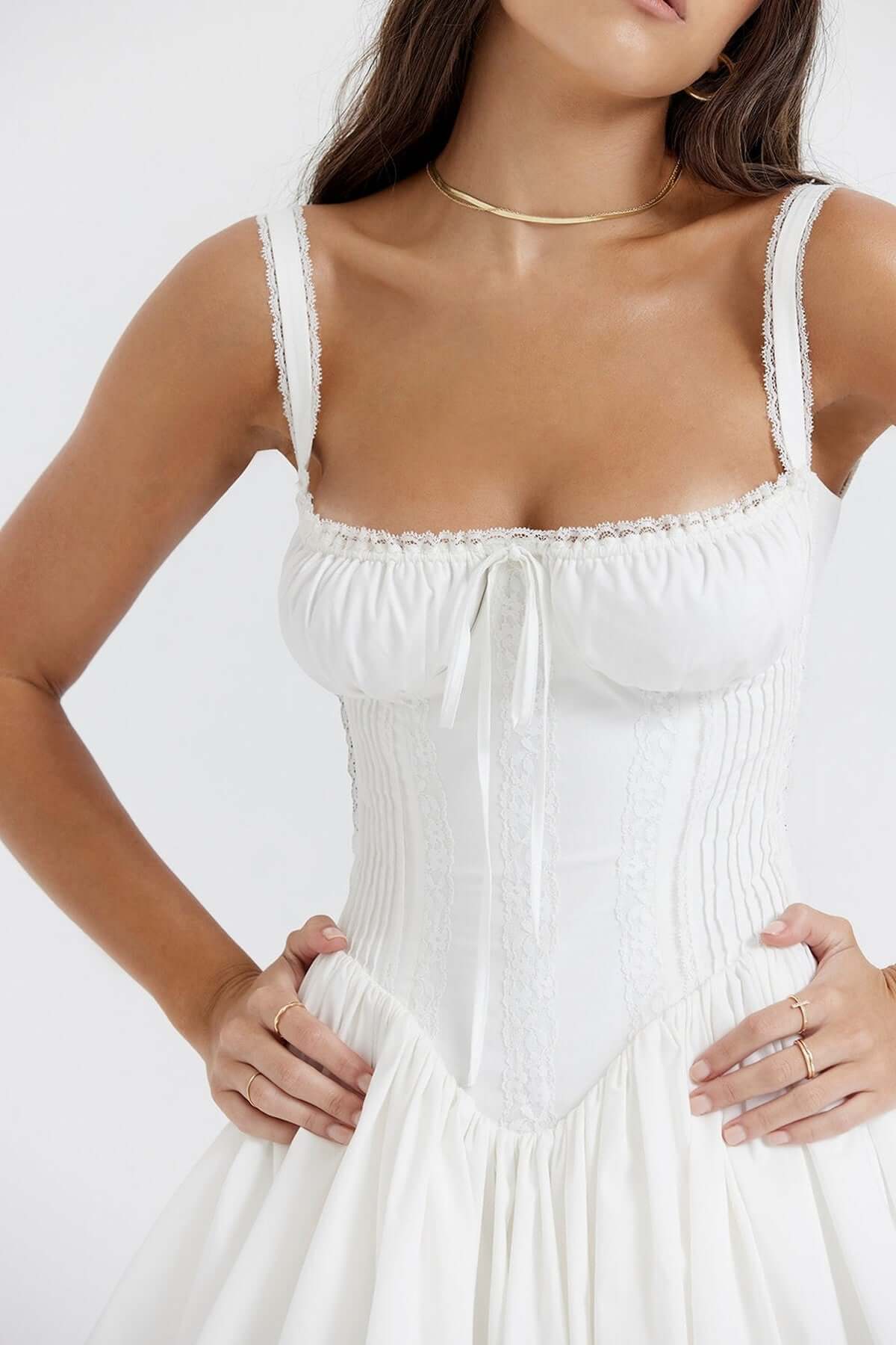 Elegant white mini dress with lace details and fitted bodice, perfect for summer events and weddings.