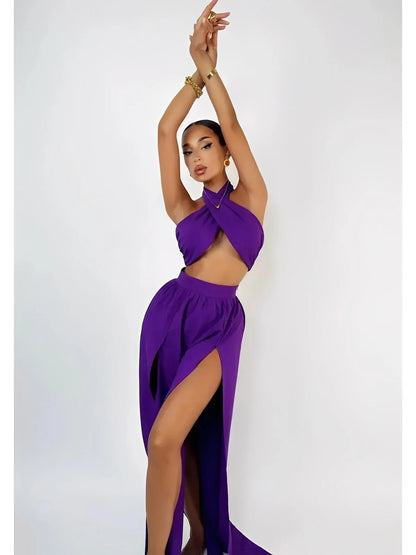Model wearing a vibrant orchid drape set featuring a halter top and high-slit maxi skirt, showcasing an elegant summer look.