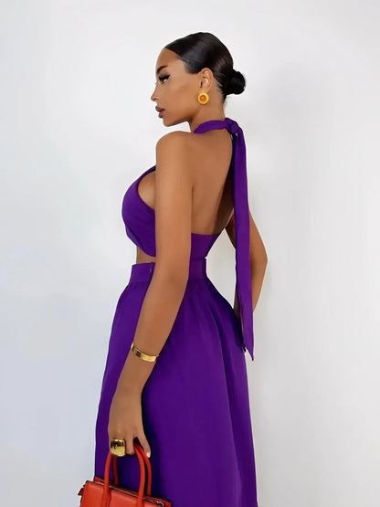 Model showcasing the Orchid Drape Set featuring a halter top and high-slit skirt in vivid purple.