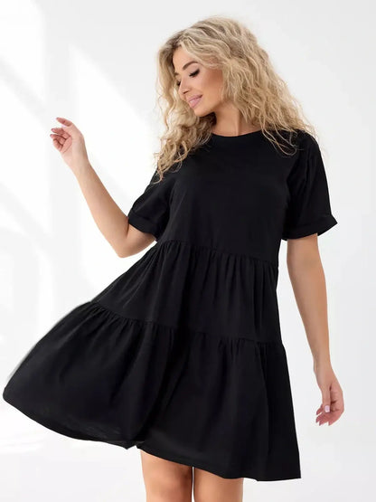 Effortless black mini dress with tiered silhouette, perfect for summer and casual occasions.